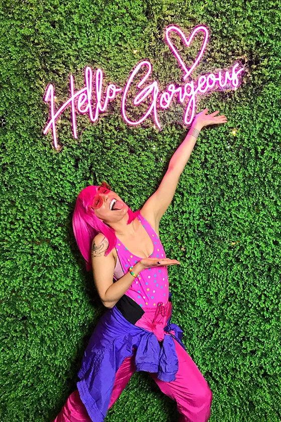 A young woman celebrating in front of a flowery backdrop